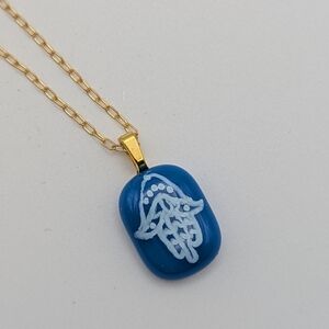 Hand crafted artisan made blue glass Israel supports Hamsa handwritten necklace.